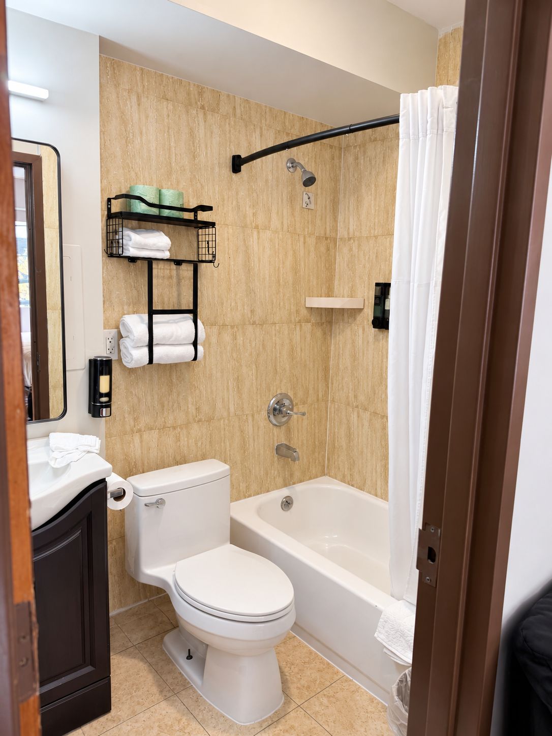 A bathroom with a toilet, a bathtub, and a shower area.