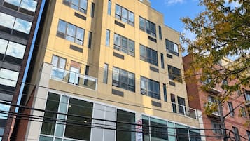Un hotel de varios pisos con un llamativo letrero que dice 'Dynasty Hotel', ventanas amplias y un diseño arquitectónico moderno.
