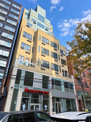 A multi-story hotel with a prominent 'Dynasty Hotel' sign, large windows, and a modern architectural design. - Dynasty Hotel and Suites New York LaGuardia Hotel (Flushing)