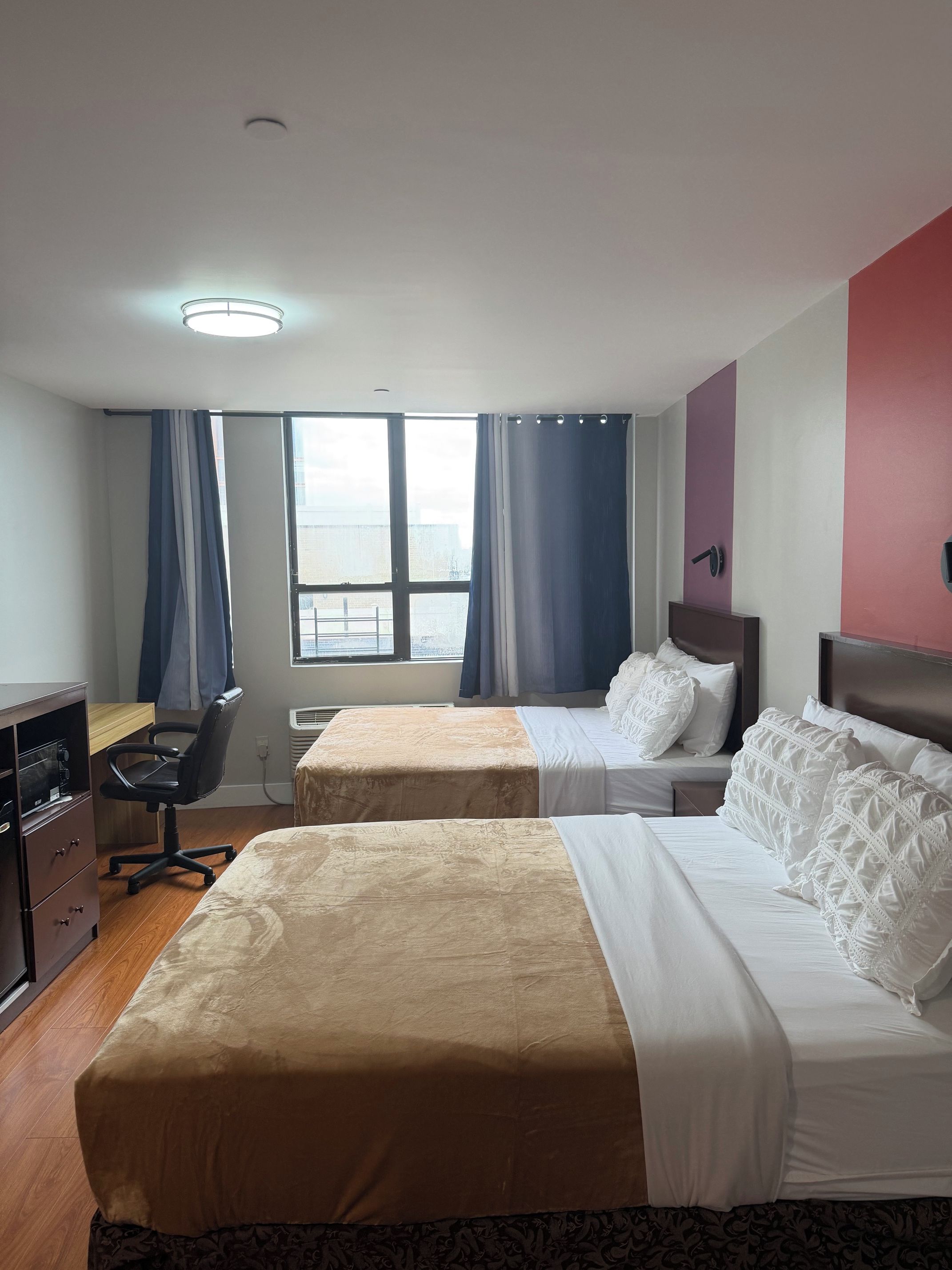 Una habitación de hotel con dos camas, un escritorio y una silla.