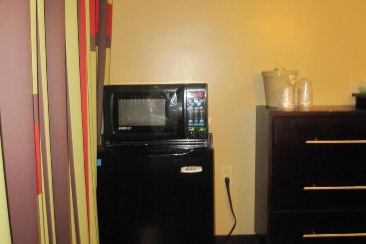 A compact kitchen with a microwave and a small refrigerator.