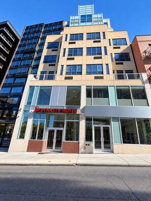 A hotel building with a modern facade, large windows, and a prominent hotel sign. - Dynasty Hotel and Suites New York LaGuardia Hotel (Flushing)