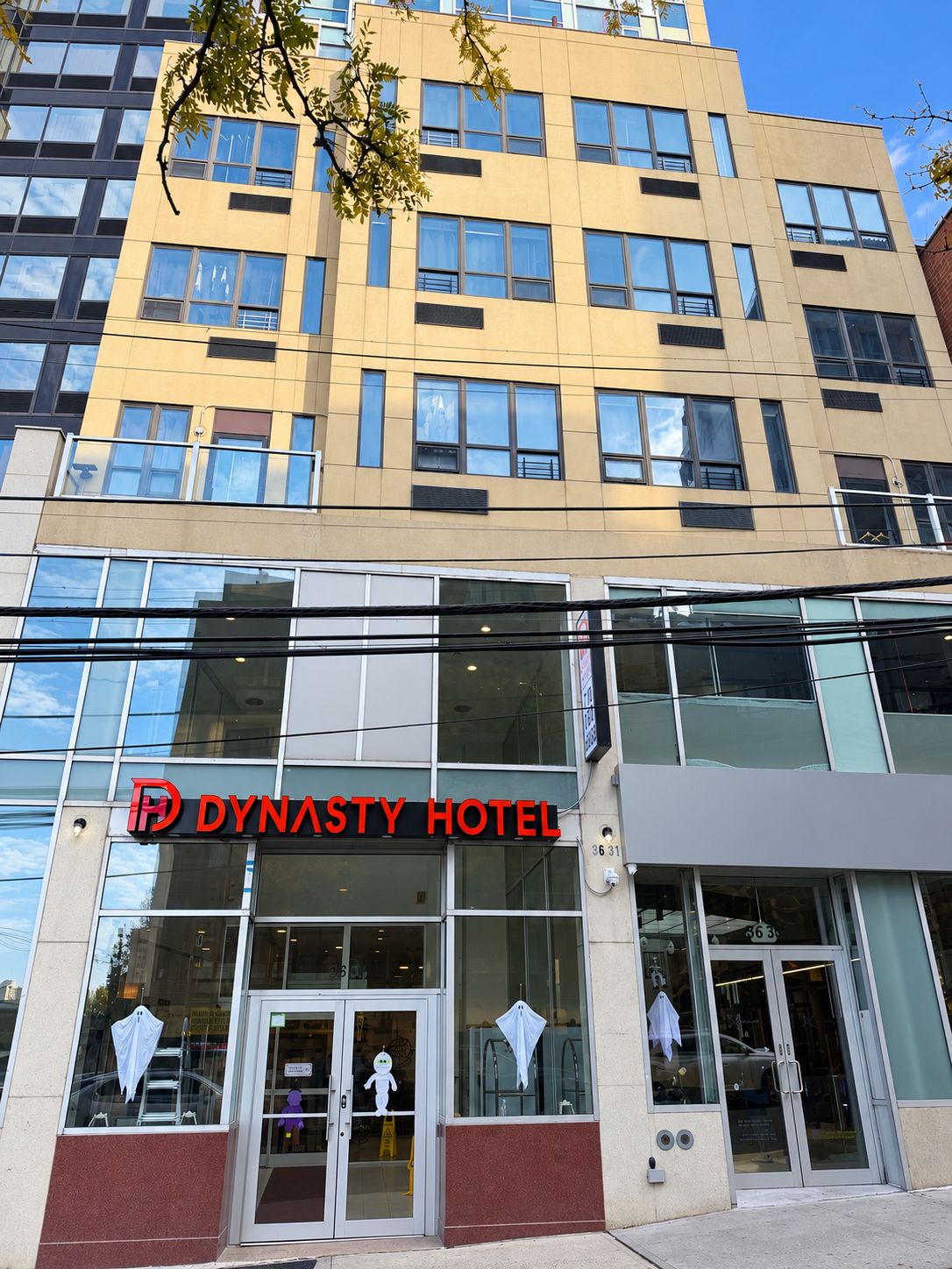 A modern hotel building with a prominent 'Dynasty Hotel' sign.
