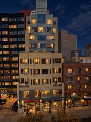 A multi-story hotel with a modern design, featuring a prominent sign for the Dynasty Hotel. - Dynasty Hotel and Suites New York LaGuardia Hotel (Flushing)