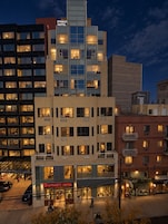 A multi-story hotel with a modern design, featuring a prominent sign for the Dynasty Hotel.