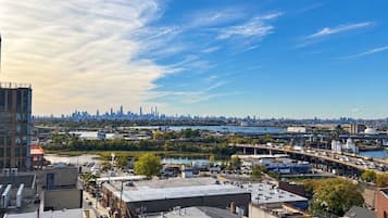 A cityscape with a clear sky, buildings, and a parking lot.