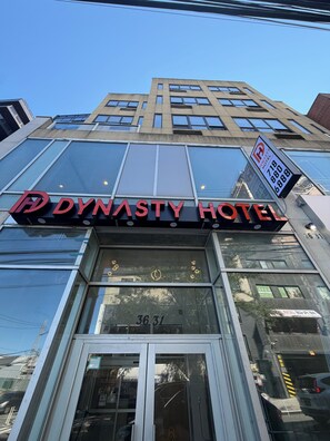 The exterior of the Dynasty Hotel with a clear view of the entrance and the building's facade. - Dynasty Hotel and Suites New York LaGuardia Hotel (Flushing)