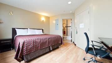 Quarto com cama, escrivaninha e cadeira.