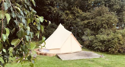 Eartha, a furnished bell tent in field and woodland surroundings