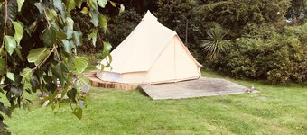Eartha, a furnished bell tent in field and woodland surroundings