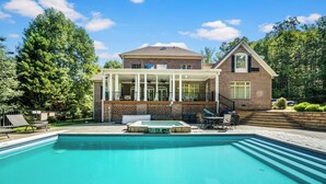 A two-story house with a swimming pool, a covered patio, and a brick exterior. - Norris Lake Manor-Exquisite Waterfront with *Private Dock *Pool *Hot tub *Game room  (Caryville)