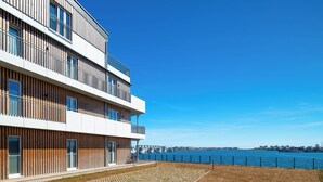 A modern multi-story building with balconies overlooking a waterfront. - Admiralsdeck Panoramablick, Finnische Sauna, 3 Baeder, Fahrstuhl, 2 Terrassen (Olpenitz)