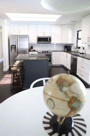 Enjoy cooking and dining in this well-equipped kitchen with a large island, sink, and dining table.