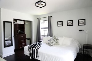 A bedroom with a large bed, a wardrobe, a desk, and a window with curtains. - Edgy Modern house with Heated Salt Water Pool (Naples)