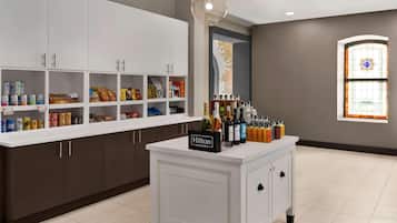 Una cocina con armarios blancos, un minibar y un letrero de minibar que dice "Hilton Honors".