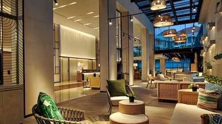 A spacious lobby with high ceilings, modern lighting fixtures, and comfortable seating areas.