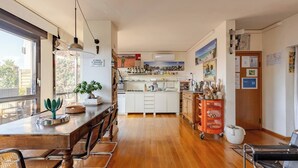 A modern kitchen with a wooden dining table, chairs, and a hanging light fixture. - Palladio20 Loft & Terrace (Verona)