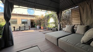 An outdoor patio area with a sofa, potted plants, and a view of the surrounding landscape. - Palladio20 Loft & Terrace (Verona)