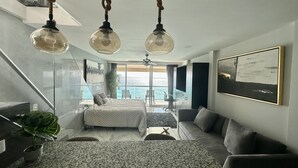 A modern bedroom with a large bed, a seating area, and a balcony with a view. - Beachfront PENTHOUSE - Best Views + 3-Beds + 2 Balconies + Maid Service (Cancún)