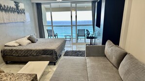 A modern bedroom with a bed, a sofa, and a view of the ocean. - Beachfront PENTHOUSE - Best Views + 3-Beds + 2 Balconies + Maid Service (Cancún)
