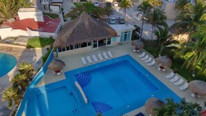 A swimming pool with lounge chairs and palm trees. - Beachfront PENTHOUSE - Best Views + 3-Beds + 2 Balconies + Maid Service (Cancún)