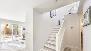 Ein modernes Interieur mit Treppe, weißen Wänden und Holzboden.