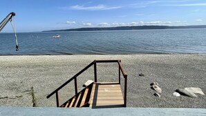Una spiaggia di ciottoli con una panchina di legno e un canna da pesca.