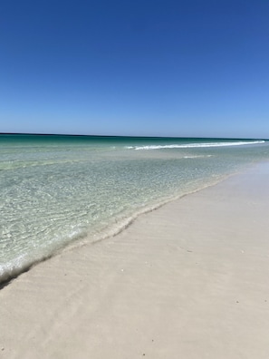 A beach with clear water and a sandy shore.