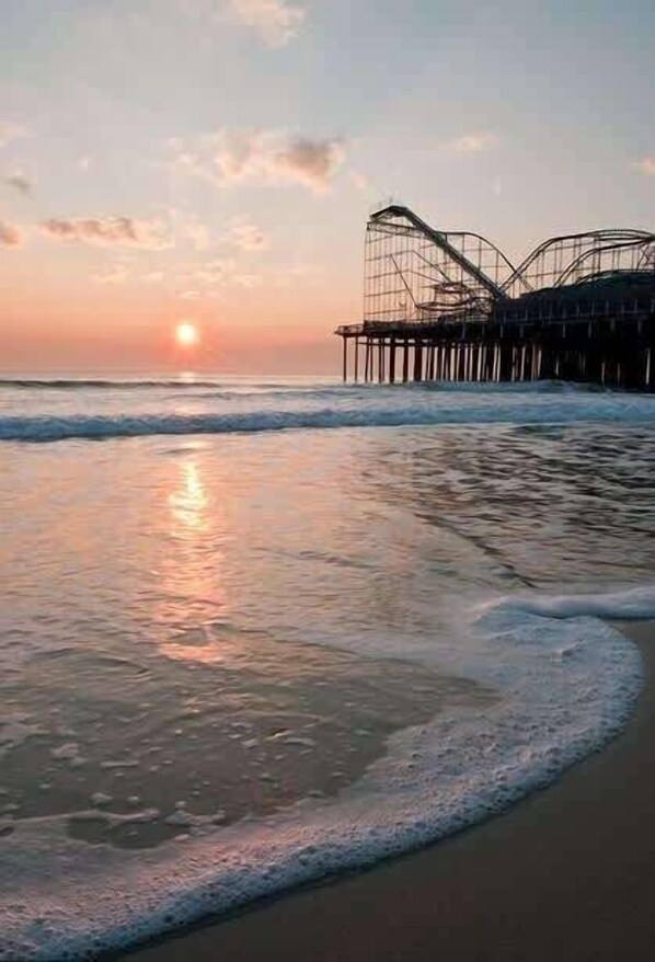 A beach with a pier extending into the water.