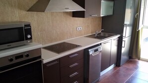 Una cocina moderna con microondas, estufa, pileta y lavavajillas.