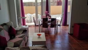 Una sala de estar con un sofá, una mesa de centro y un comedor con sillas y una mesa.