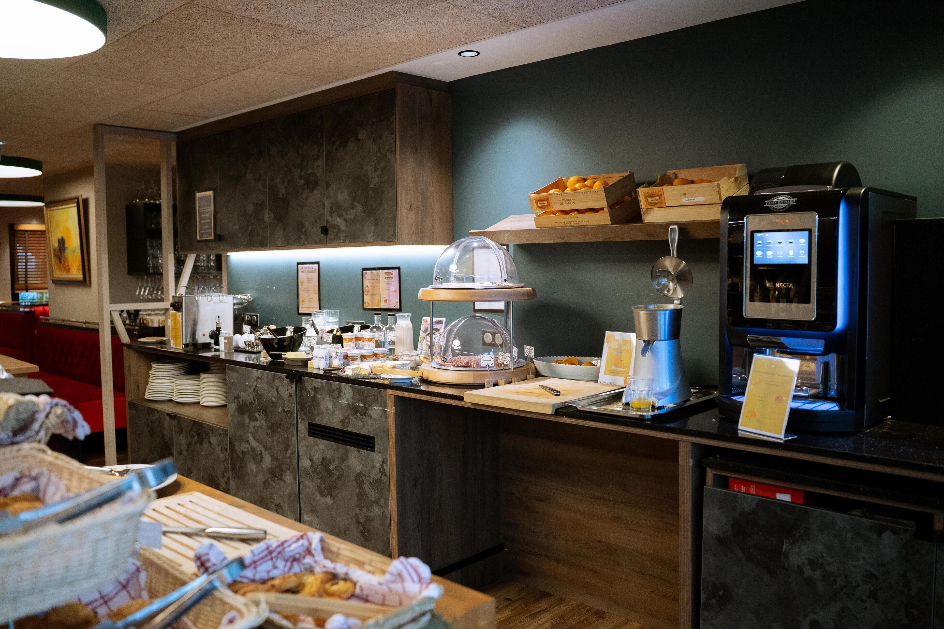 Een koffiebar met een koffieapparaat, een vitrine met eten en diverse keukenapparaten.