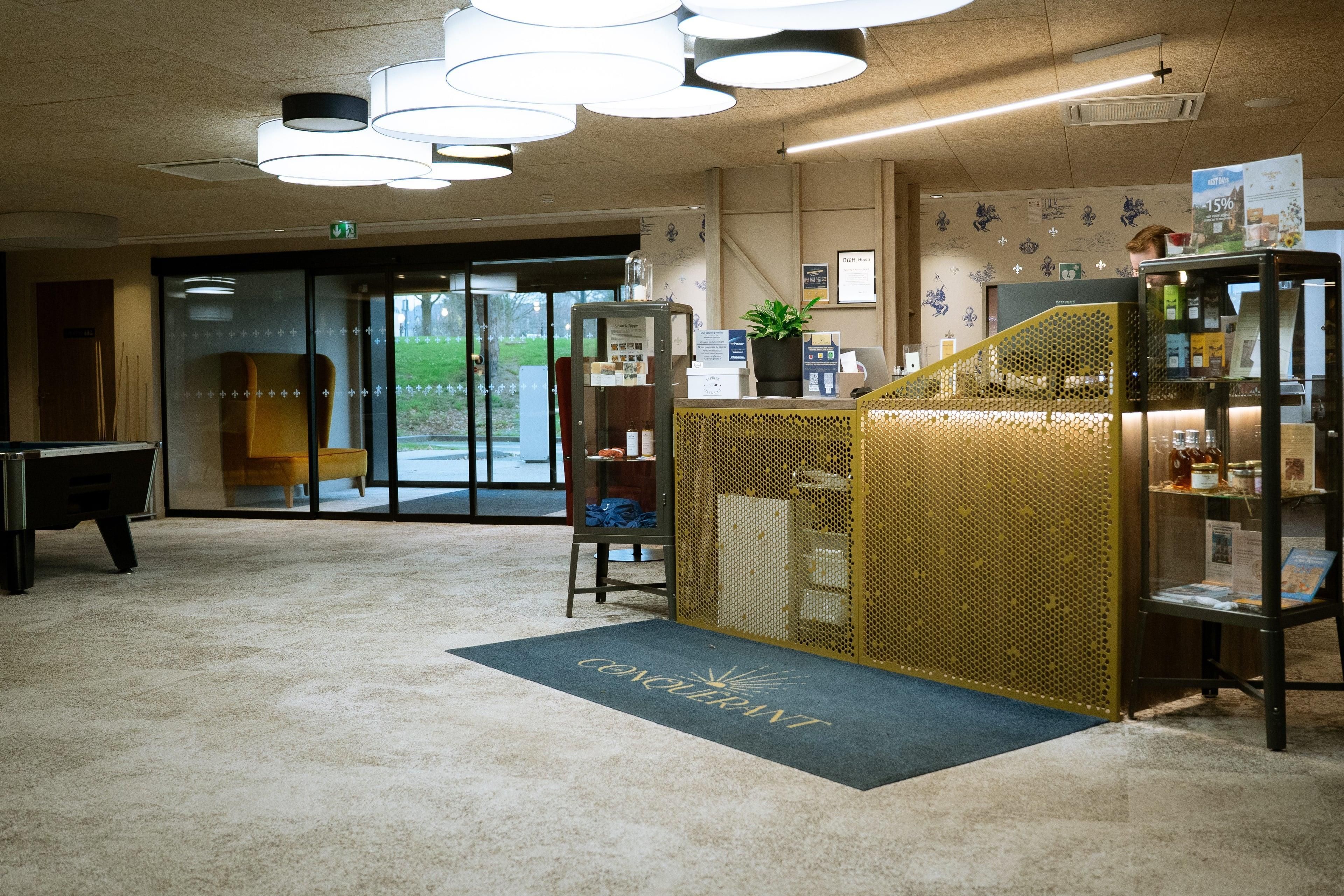 Un hall d’hôtel comprenant un comptoir d’accueil, une table de billard et une vue sur l’extérieur.