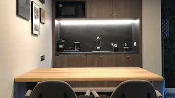 A modern kitchen with a wooden countertop, two chairs, and a built-in microwave.
