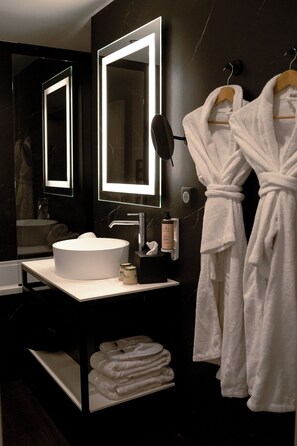 A modern bathroom with a round sink, a large mirror, and two white bathrobes hanging on hooks. - Best Western Plus Le Conquerant Rouen Nord (Bois-Guillaume)