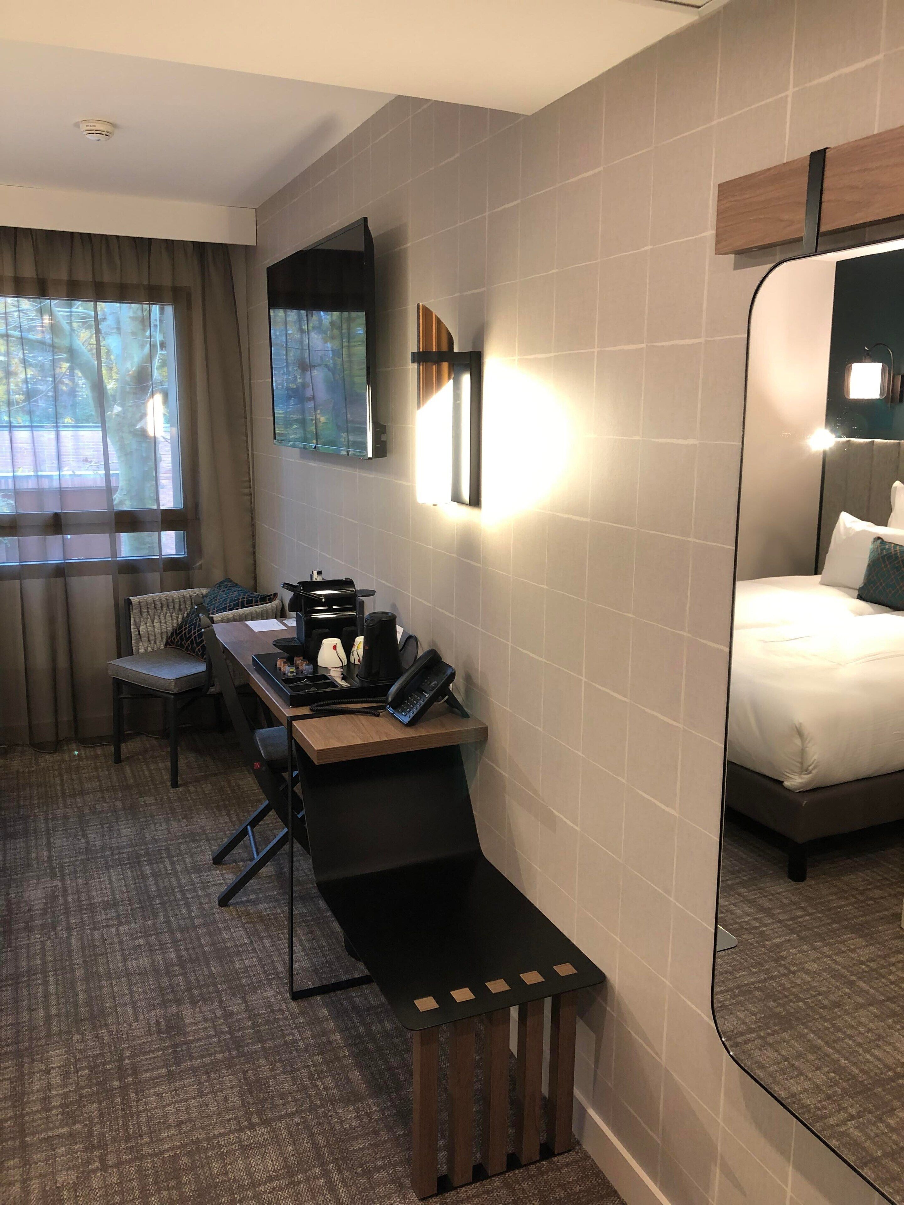 Una habitación de hotel con escritorio, silla y cama.