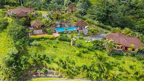 An aerial view of a resort with multiple buildings, a swimming pool, and lush greenery. - Wide Luxury Home with Pool & Jacuzzi access & Amazing Volcano and Lake views (El Castillo)