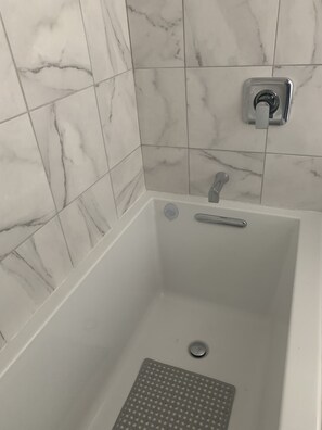 A bathroom with a white bathtub, a showerhead, and a toilet. - Waterfront Studio Private Guest Suite at Dungeness Barn House (Sequim)