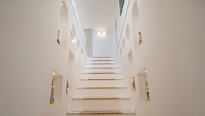 Een trap met witte muren en kleine decoratieve objecten aan weerszijden.
