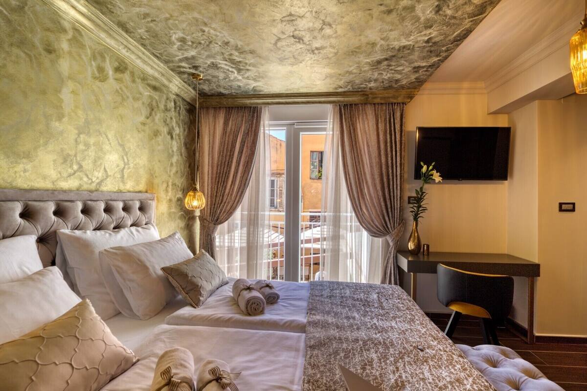 A hotel room with a large bed, a desk, and a TV.