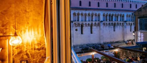 Un balcón con vista a un edificio histórico con arcos y un letrero de restaurante.