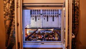 A view from a window overlooking a courtyard with people dining. - Luxury Rooms VINDEMIÆ (Zadar)