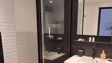 Een douche, een haardroger, zeep, toiletpapier