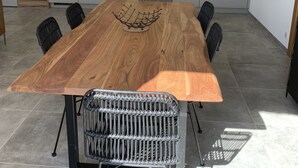 Eine moderne Küche mit einem Holztisch, schwarzen Stühlen und einem eingebauten Backofen.