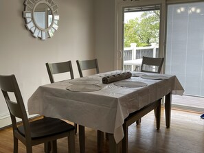 Enjoy meals in this dining area with a table for four, surrounded by comfortable chairs and a decorative mirror.