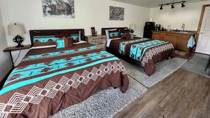 Une chambre d’hôtel avec deux lits, une kitchenette et une salle de bain.