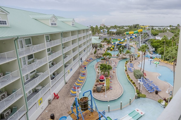 A hotel with multiple balconies, a pool area with slides, and a water park.