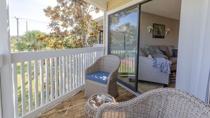 A balcony with wicker furniture and a sliding glass door leading to a living area. - La Casa Del Mar 608 Star5vacationscom (Dunedin)