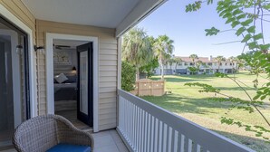 A balcony with a wicker chair and a sliding glass door leading to a bedroom. - La Casa Del Mar 610 Star5vacations.com (Dunedin)