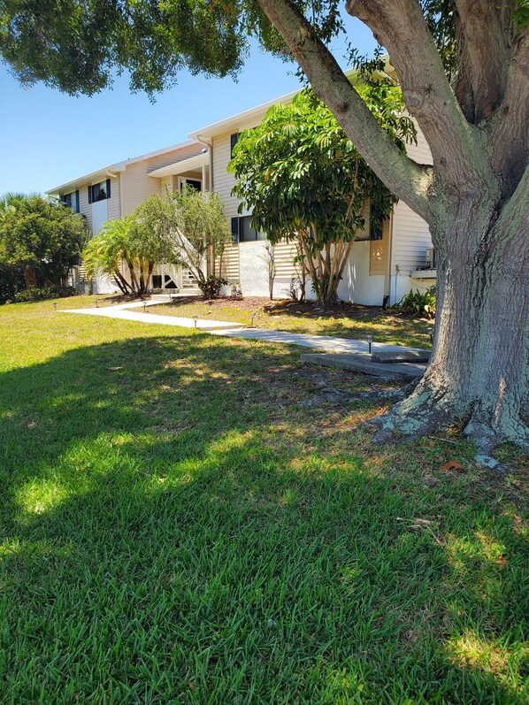 A two-story building with a covered porch and a well-maintained lawn. - La Casa Del Mar 602 Star5vacations (Dunedin)
